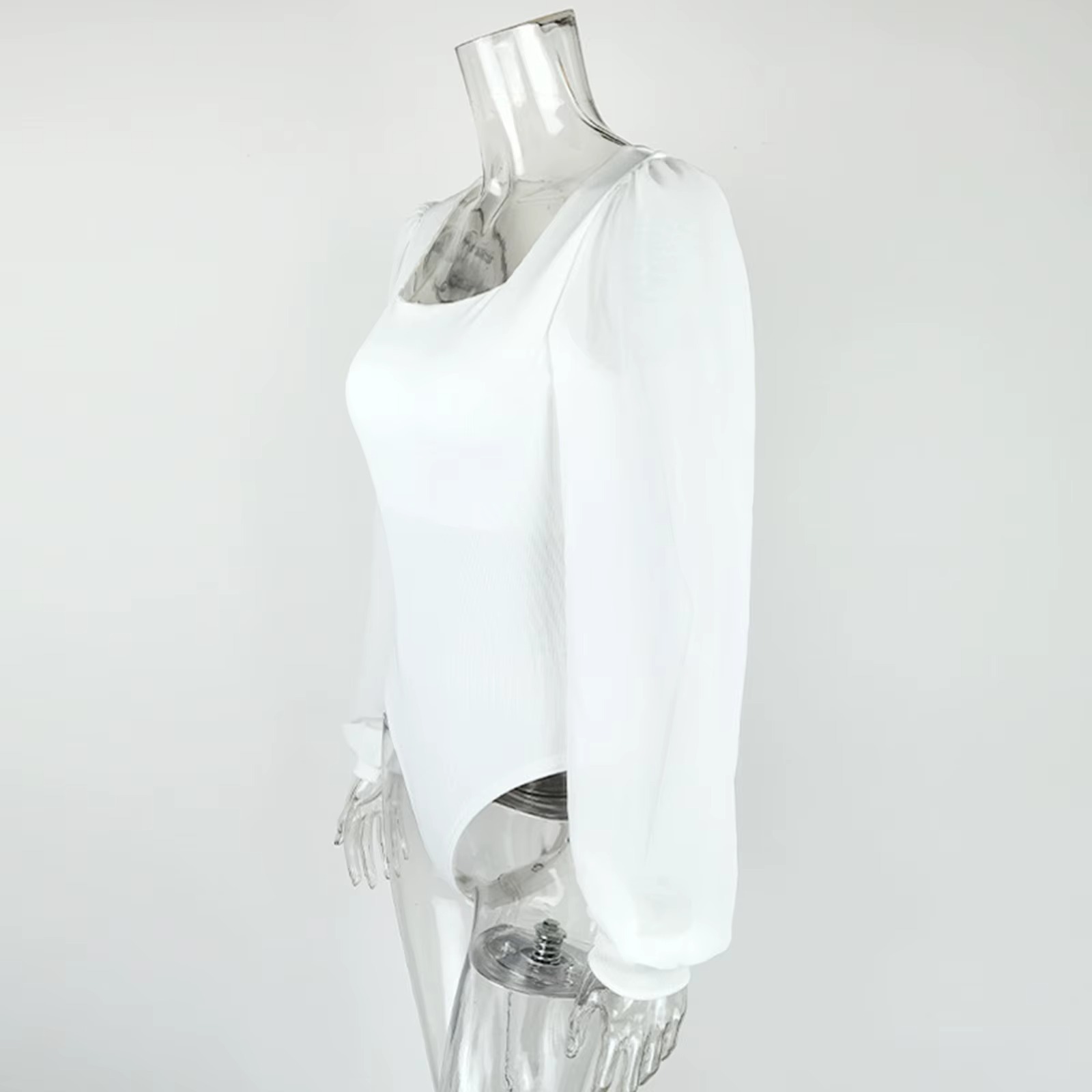 Side profile of a white puffy sleeve thong bodysuit on a mannequin, showing the puff sleeve volume, body length, and thong cut from a lateral angle