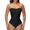 Model posing in a strapless black front closure body shaper bodysuit with an integrated waist-cinching panel.