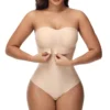 Studio portrait of a woman wearing a strapless nude front closure body shaper bodysuit with built-in underwire-free cups.
